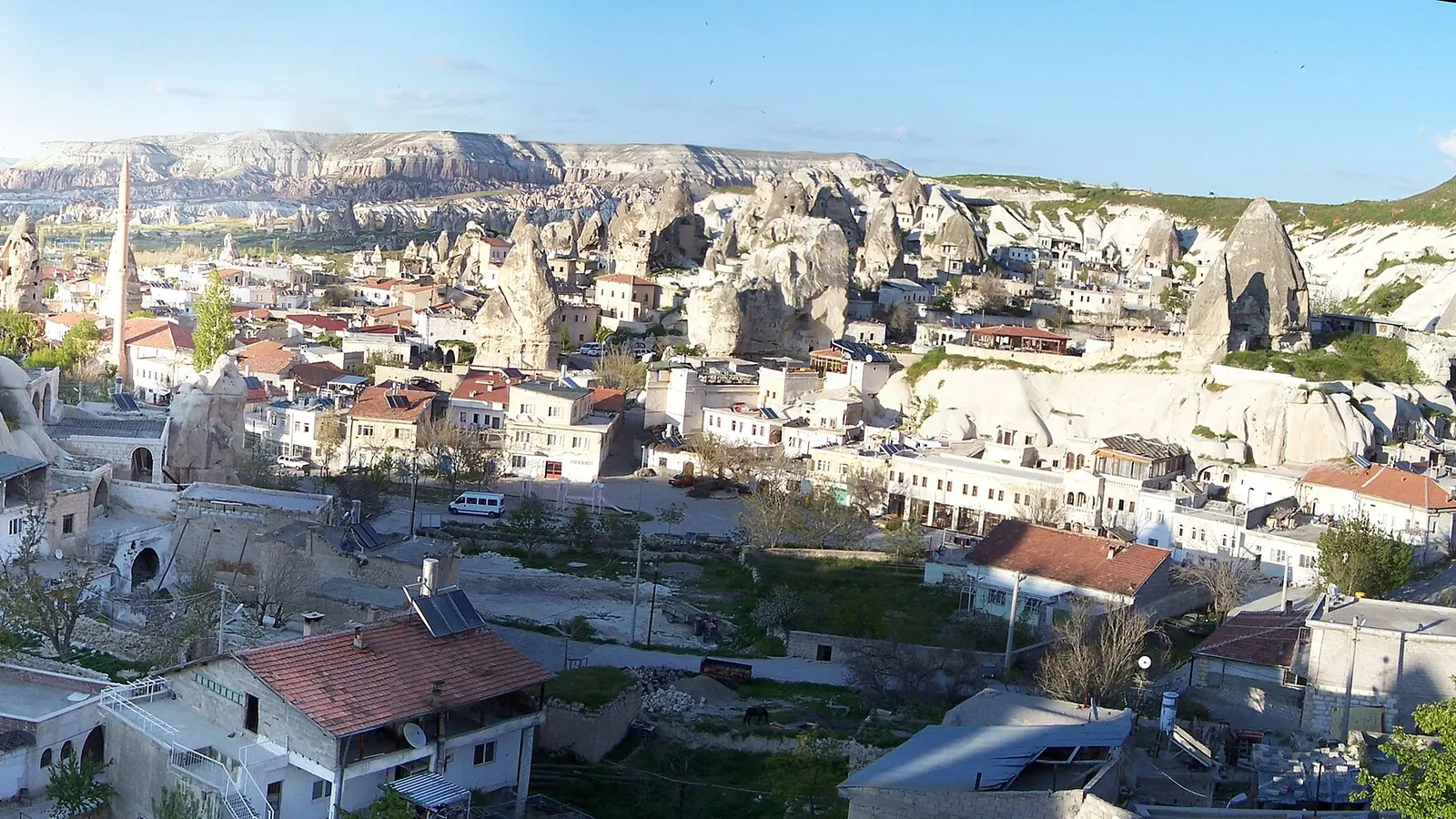 Göreme'nin geniş panoraması; kaya oyma evler, peri bacaları ve kasabanın yayıldığı vadi birlikte görünüyor.